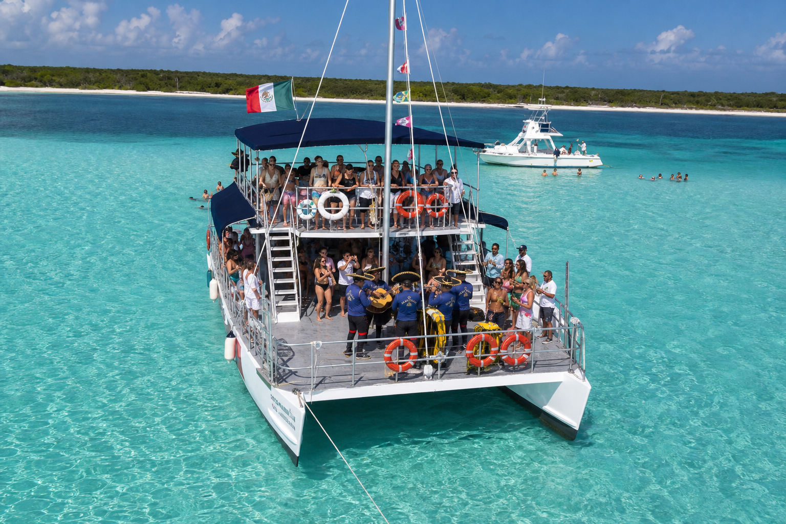 Catamarán de dos pisos con ambiente a bordo navegando en aguas turquesas de Cozumel